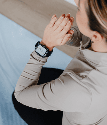 Woman wearing a smartwatch while sitting, shown using a digital cough-monitoring device