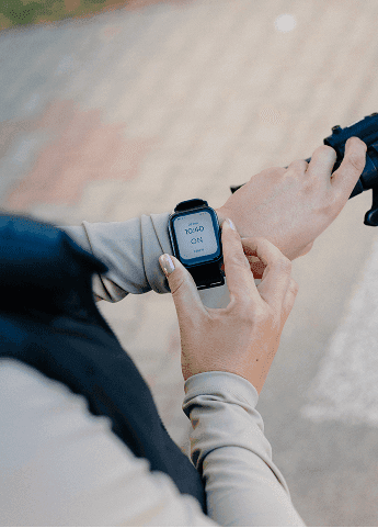 Close-up of hands using a smartwatch to track cough activity during daily routine